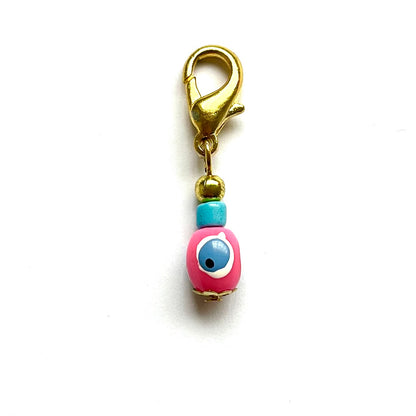 Pink Evil Eye with gold clasp on a white background